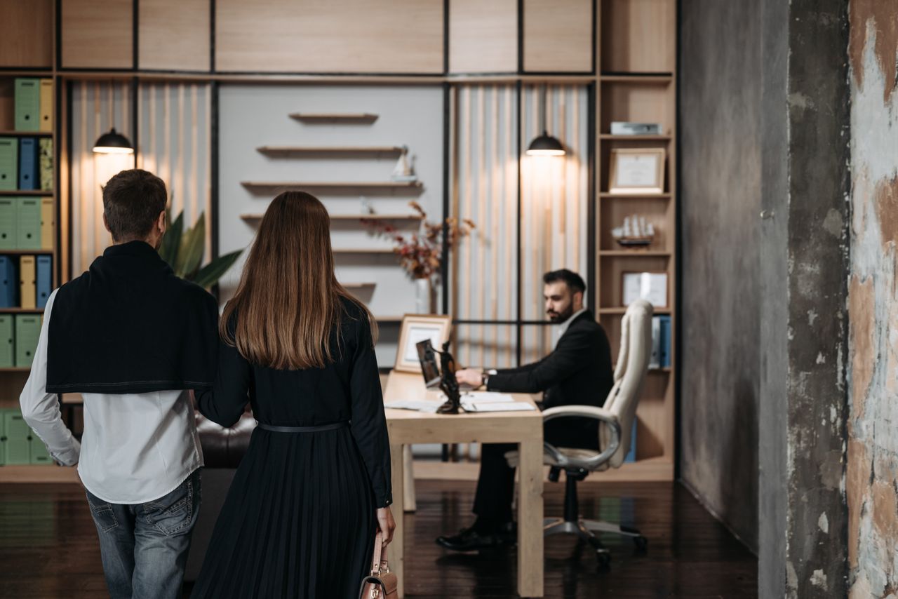 hero-gallery-03 A couple approaches a lawyer in a contemporary office setting for a professional consultation.